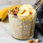 Banana chia pudding in a glass jar with banana slices and walnuts on top