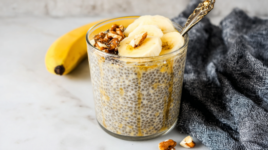 Banana chia pudding in a glass jar with banana slices and walnuts on top